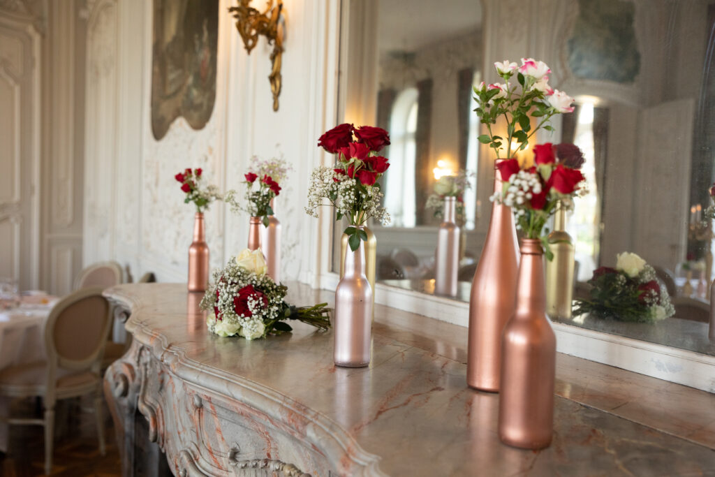 La cheminée du château de Dangu élégamment décorée avec des compositions florales rouges et blanches