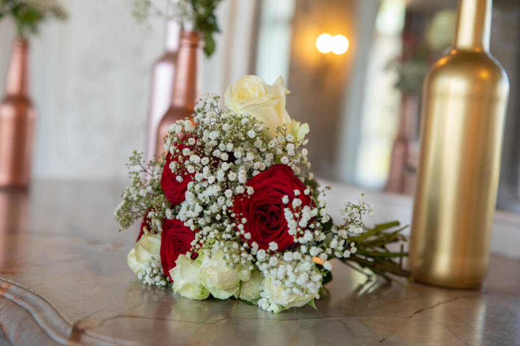 La cheminée du château de Dangu élégamment décorée avec des compositions florales rouges et blanches